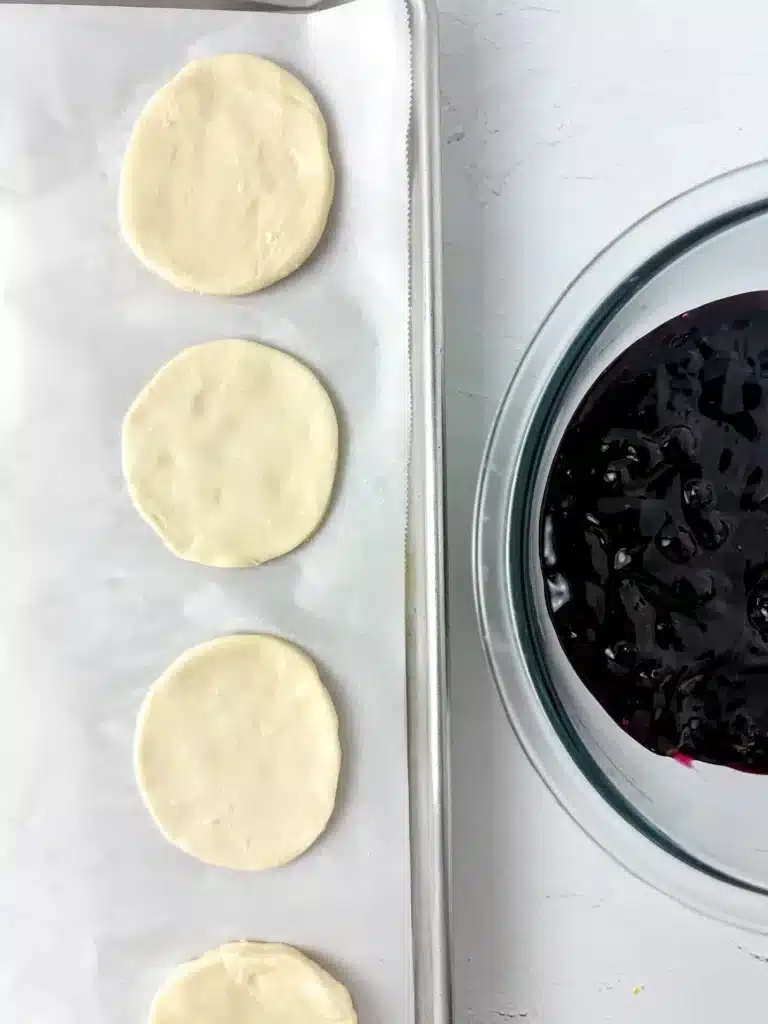 Blueberry Earth Day Hand Pies - Cultivating Brilliant Minds circles cut out of puff pastry next to blueberry pie filling