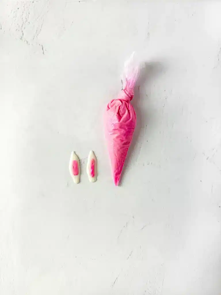 Bunny Chocolate Spoons - Cultivating Brilliant Minds pink melted chocolate in a piping bag white pink chocolate piped on top of white chocolate