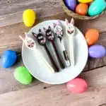 Bunny Chocolate Spoons - Cultivating Brilliant Minds chocolate spoons decorated to look like bunnies on a white plate next to plastic easter eggs