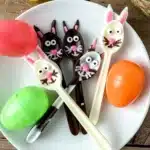 Bunny Chocolate Spoons - Cultivating Brilliant Minds chocolate spoons decorated to look like bunnies on a white plate next to plastic easter eggs