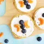 Butterfly Garden Waffles: A Spring Breakfast Idea For Kids - Cultivating Brilliant Minds waffles with whipped cream and blueberries and oranges arranged to look like a butterfly