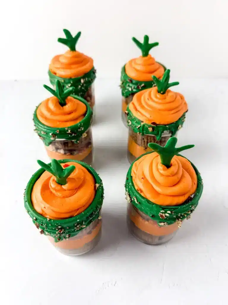 Carrot Cake Jars For Easter - Cultivating Brilliant Minds a jar with two cupcakes in it with orange and green icing to look like a carrot