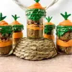 Carrot Cake Jars for Easter - Cultivating Brilliant Minds a jar with two cupcakes in it with orange and green icing to look like a carrot