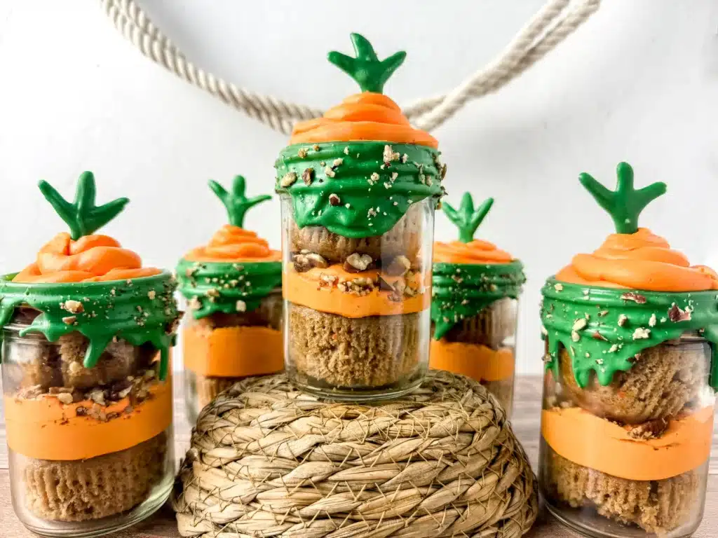 Carrot Cake Jars For Easter - Cultivating Brilliant Minds a jar with two cupcakes in it with orange and green icing to look like a carrot
