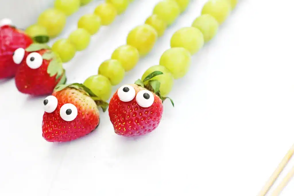 Caterpillar Grape Skewers - Cultivating Brilliant Minds skewers with grapes, a strawberry, and candy eyes on it to look like a caterpillar