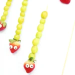 Caterpillar Grape Skewers - Cultivating Brilliant Minds skewers with grapes, a strawberry, and candy eyes on it to look like a caterpillar