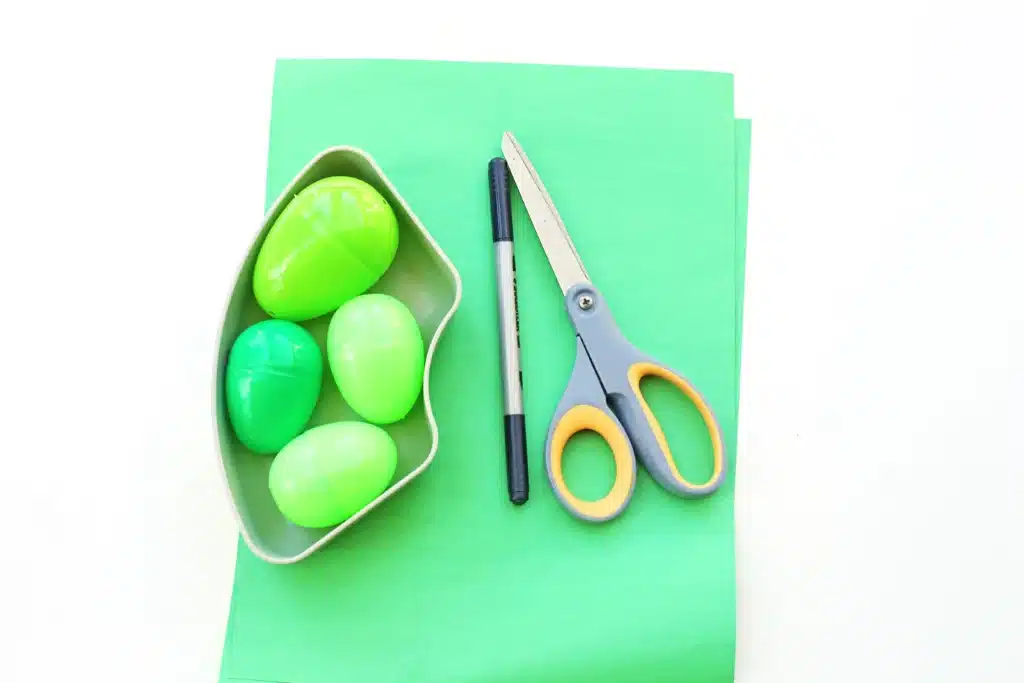Dinosaur Easter Basket For Kids - Cultivating Brilliant Minds green construction paper, scissors, a black marker, and green plastic easter eggs