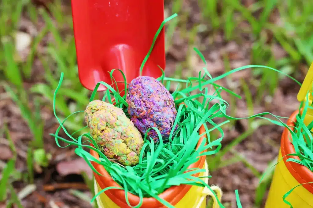 Rain boots Easter basket for kids - Cultivating Brilliant Minds rain boots with easter grass, seed bomb eggs, and toy garden tools inside