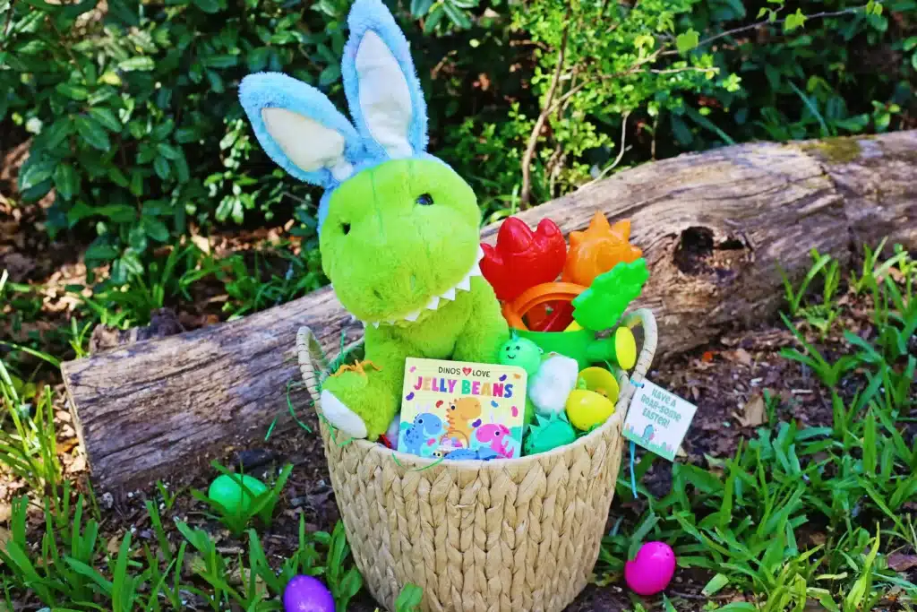 Dinosaur Easter Basket For Kids - Cultivating Brilliant Minds a dinosaur easter basket for kids that has a plush dinosaur, a dinosaur book, plastic easter eggs decorated to look like dinos, and dinosaur toys.
