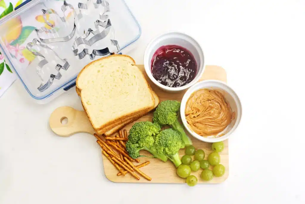 Dinosaur Lunch Idea - Cultivating Brilliant Minds bread, peanut butter, jelly, broccoli, green grapes, and pretzels