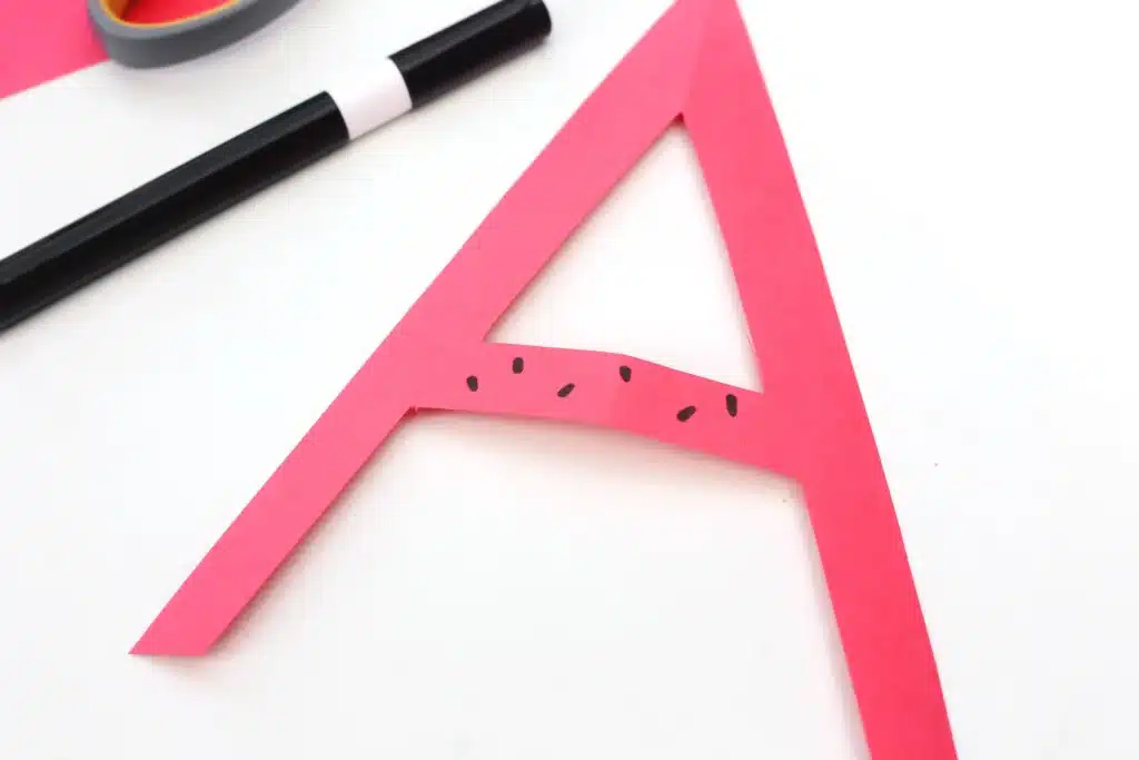 Letter A Apple Craft - Cultivating Brilliant Minds the letter a cut out of red construction paper with seeds drawn on with a marker