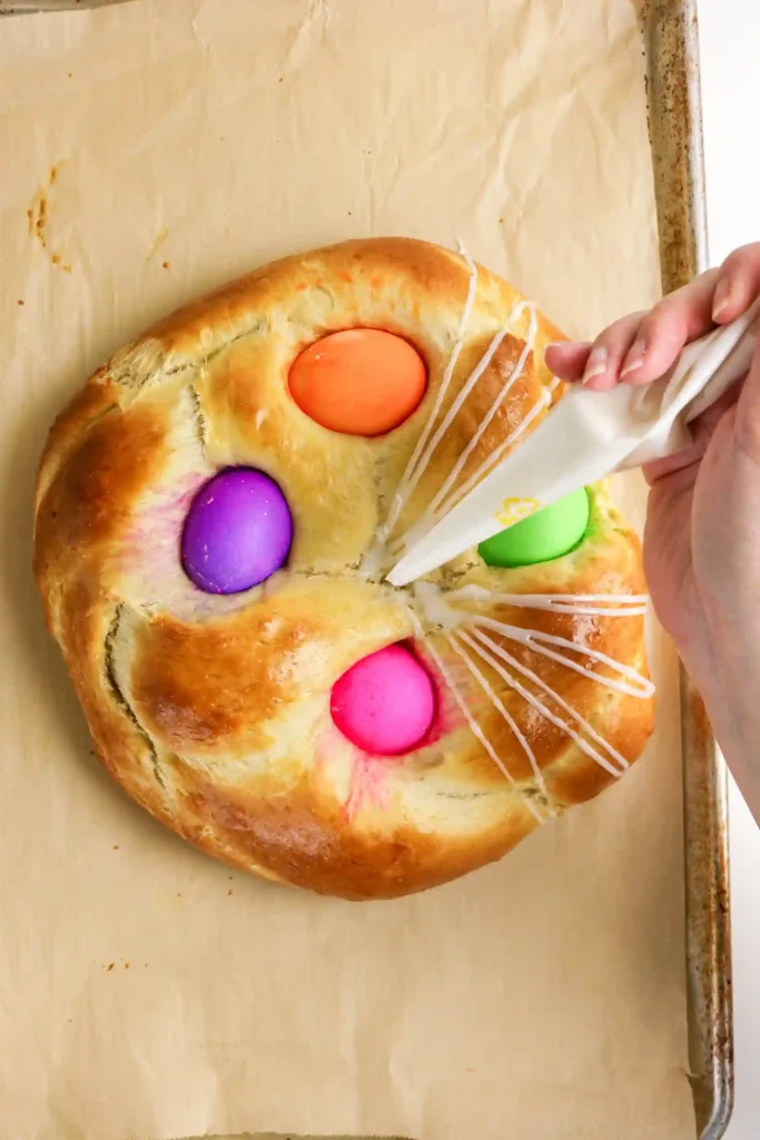 Italian Easter Bread Recipe - Cultivating Brilliant Minds drizzling glaze over the italian easter bread
