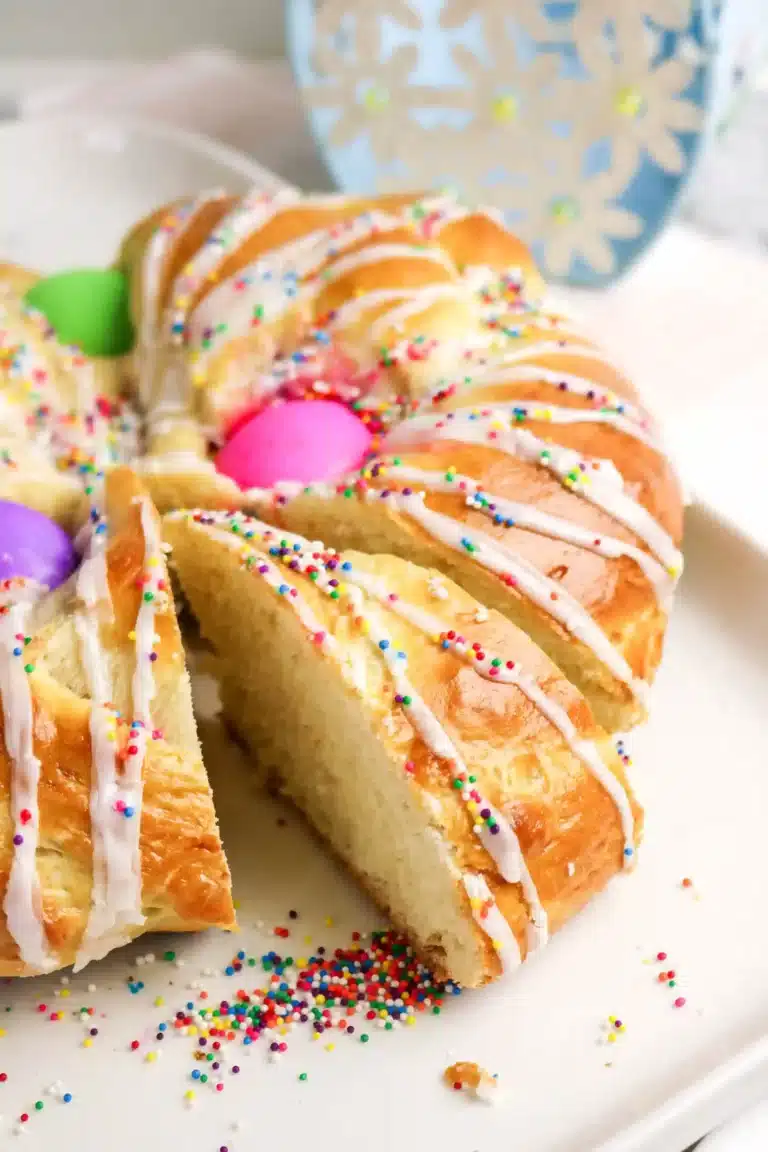 a braided italian easter bread with colored eggs, glaze, and sprinkles