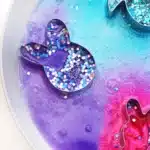 Fizzy Bunny Experiment - Cultivating Brilliant Minds cookie cutters on a plate with baking soda, glitter, food coloring, and vinegar in it to create a "volcano"