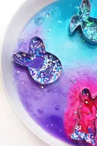 cookie cutters on a plate with baking soda, glitter, food coloring, and vinegar in it to create a "volcano"