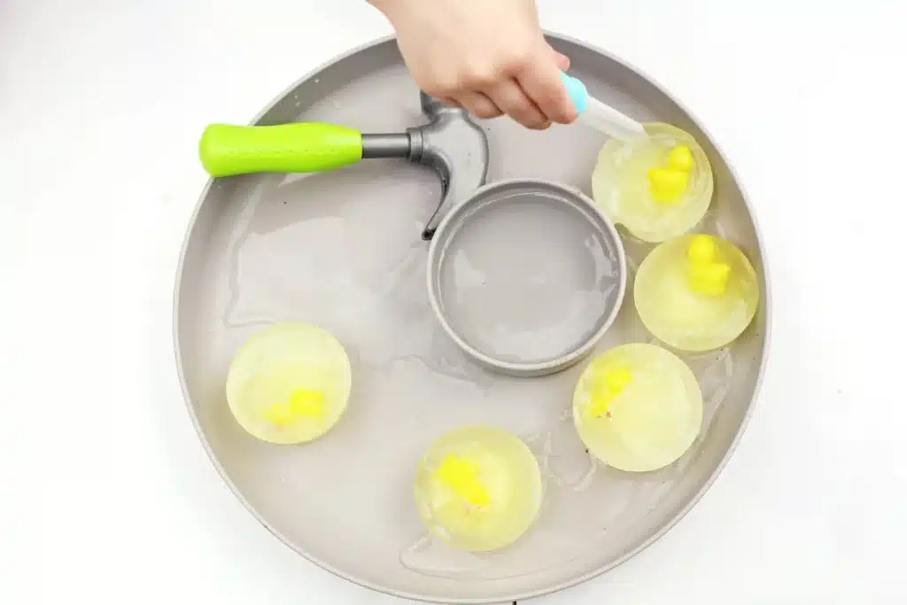 Frozen Chick Rescue Activity - Cultivating Brilliant Minds a kid using a dropper to drop warm water on frozen chicks