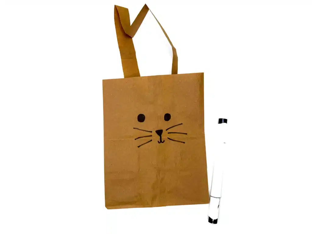 Paper Bag Bunny Basket Craft - Cultivating Brilliant Minds a paper bag decorated with a bunny face for a bunny easter basket