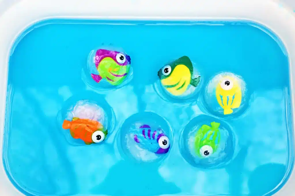 Ice Fishing Sensory Bin - Cultivating Brilliant Minds an ice fishing sensory bin that has water and toy fish frozen in ice