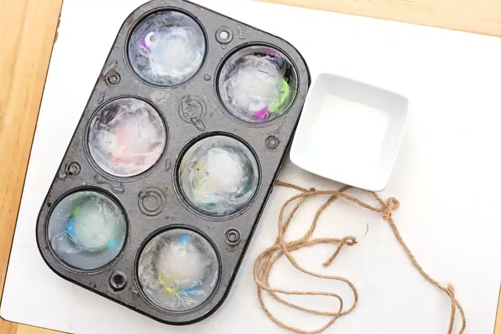 Ice Fishing Sensory Bin - Cultivating Brilliant Minds a muffin tray with fish frozen in ice, string, and salt