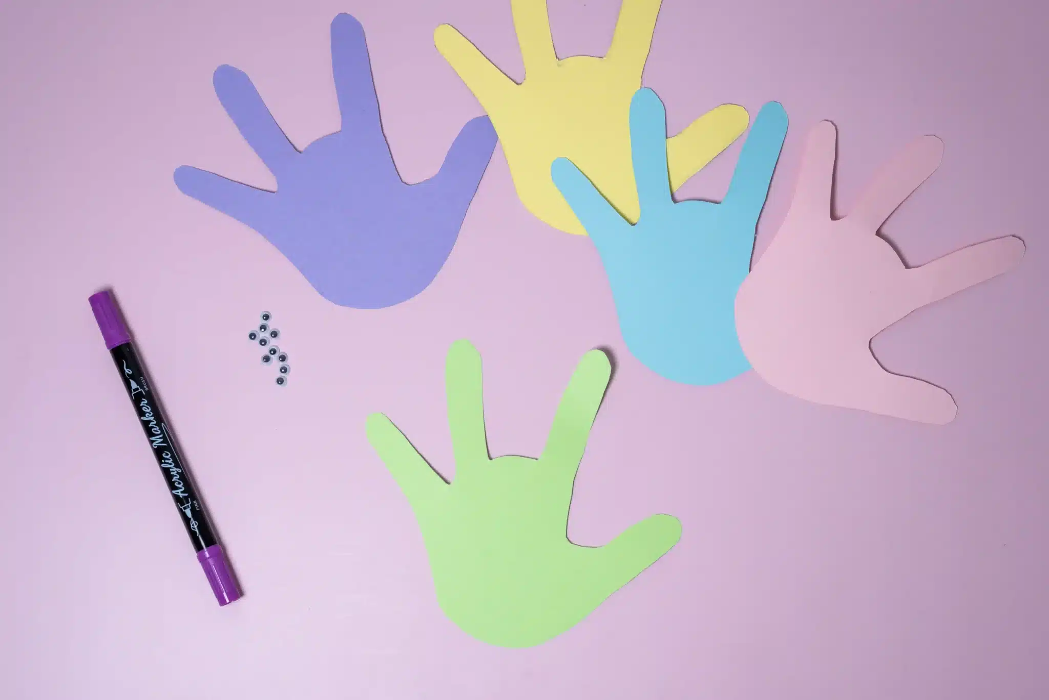 Bunny Handprint Craft - Cultivating Brilliant Minds handprints cut out of colored paper with the middle finger cut off