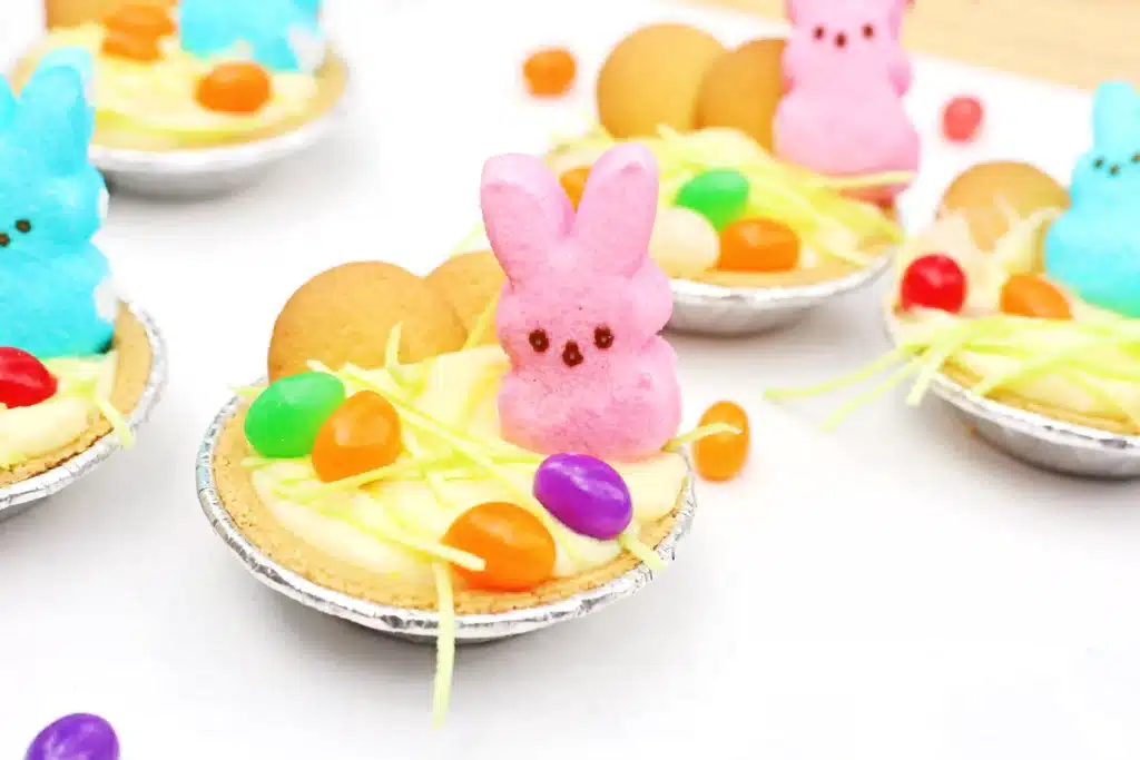 Peeps Banana Pudding Mini Pies - Cultivating Brilliant Minds a banana pudding mini pie with nilla wafers, edible grass, jelly beans, and a peeps bunny