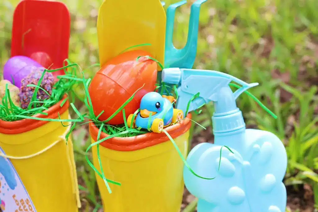 Rain boots Easter basket for kids - Cultivating Brilliant Minds rain boots with easter grass, seed bomb eggs, and toy garden tools inside
