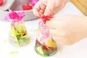 a kid putting flowers in a jar with water