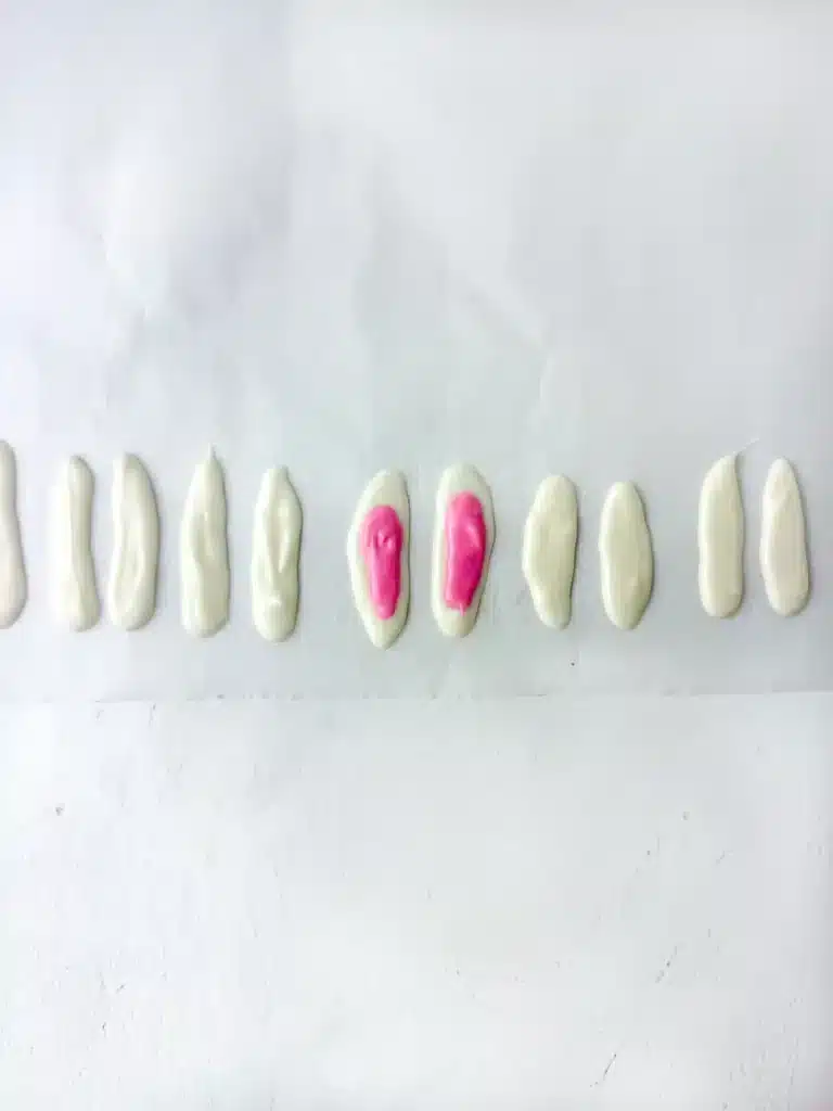 white chocolate piped into an oval with pink chocolate piped into a smaller oval on top to make bunny ears