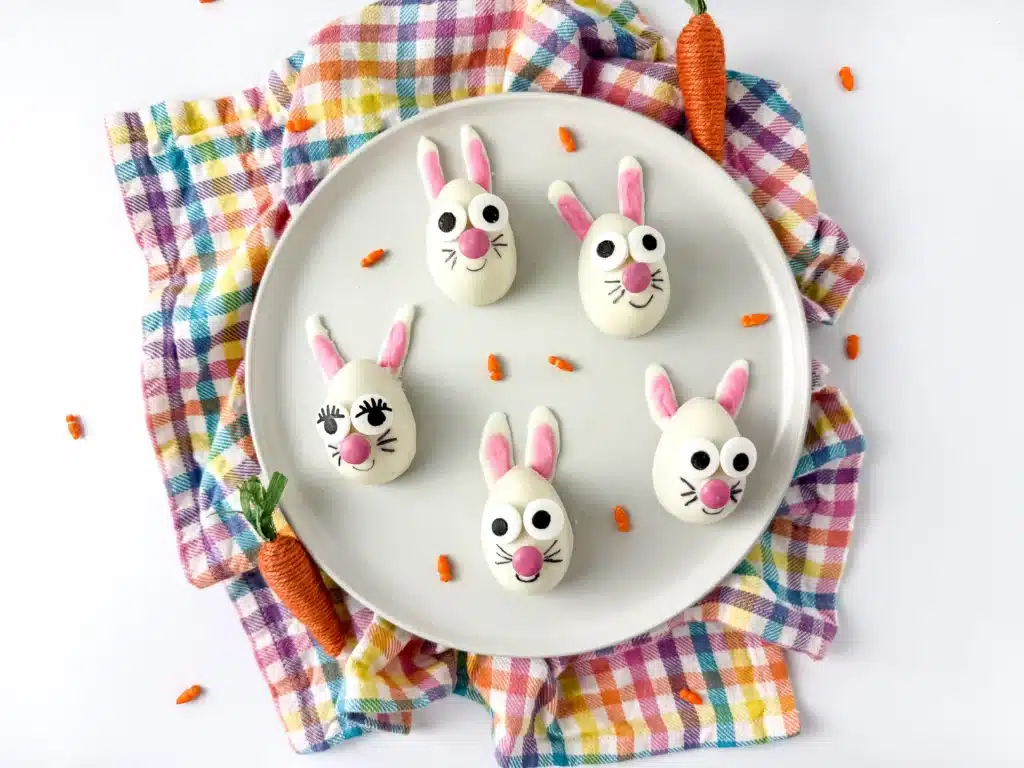 strawberry funfetti bunnies on a plate. They are white chocolate coated on a strawberry cupcake mixture, decorated to look like a bunny