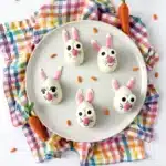 strawberry funfetti bunnies on a plate. They are white chocolate coated on a strawberry cupcake mixture, decorated to look like a bunny