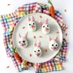 Strawberry Funfetti Bunnies - Cultivating Brilliant Minds strawberry funfetti bunnies on a plate. They are white chocolate coated on a strawberry cupcake mixture, decorated to look like a bunny