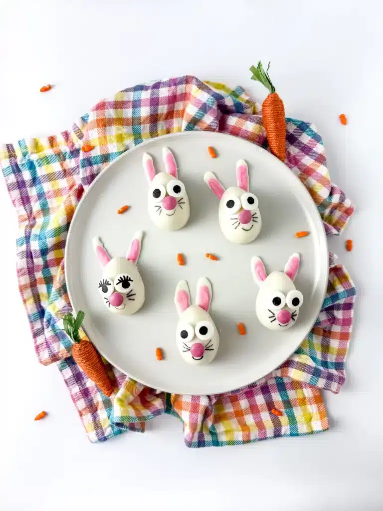 strawberry funfetti bunnies on a plate. They are white chocolate coated on a strawberry cupcake mixture, decorated to look like a bunny