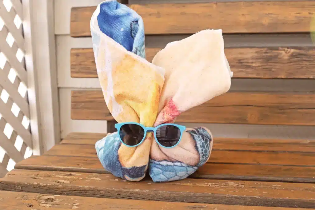 Beach Easter Basket Idea - Cultivating Brilliant Minds a DIY towel bunny that is a towel folded up to look like a bunny with sunglasses on it