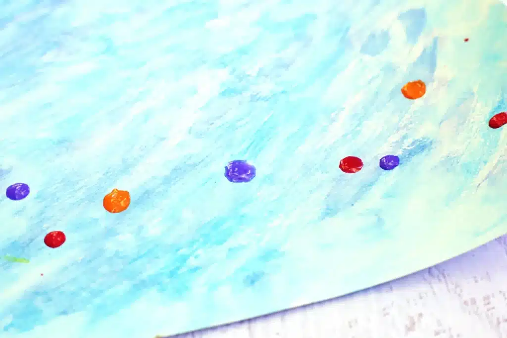 Coral Blow Painting With Straws - Cultivating Brilliant Minds drops of paint on a blue watercolor background