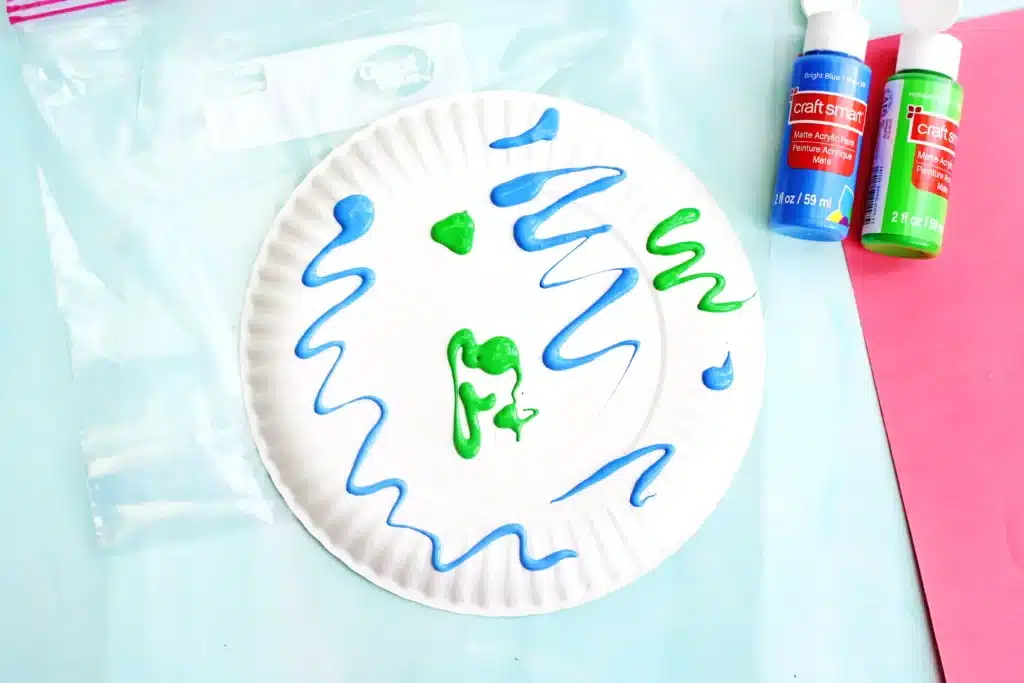 No-Mess Earth Day Painting - Cultivating Brilliant Minds blue and green paint on a paper plate