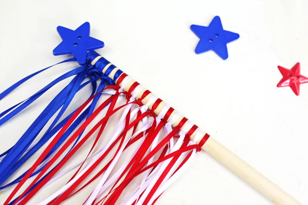 American Flag Wands - Cultivating Brilliant Minds an American flag wand fourth of july craft that uses string tied around a dowel and a star button