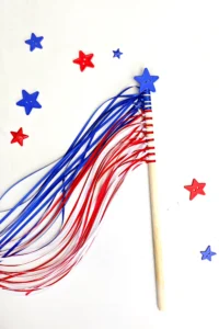 an American flag wand fourth of july craft that uses string tied around a dowel and a star button