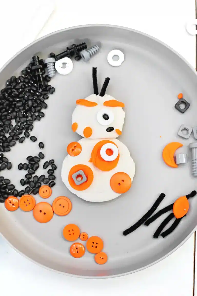 playdough, buttons, and loose parts put together to look like bb8 from star wars