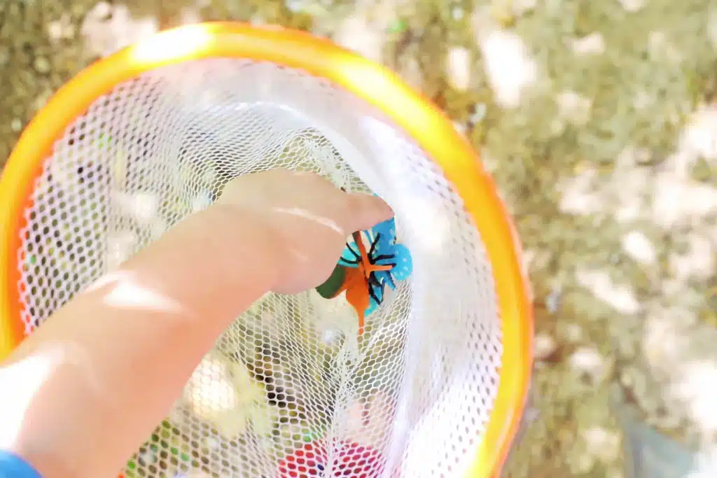 Backyard Butterfly Hunt - Cultivating Brilliant Minds a kid grabbing a fake butterfly out of a net