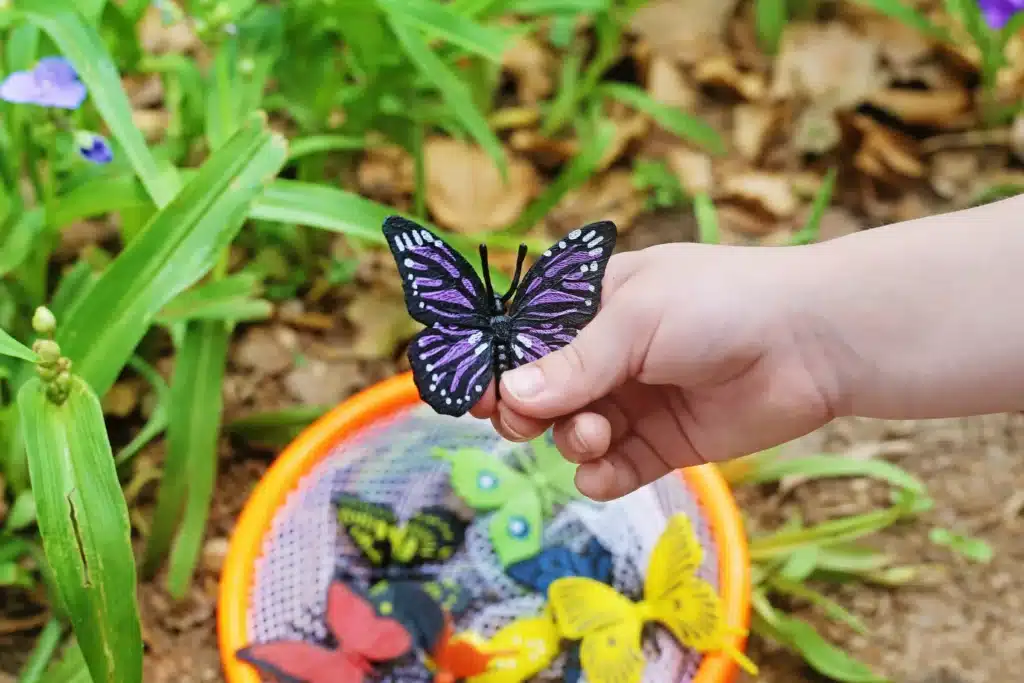 Backyard Butterfly Hunt - Cultivating Brilliant Minds a kid holding a fake butterfly