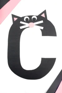 a letter c craft that uses construction paper to make a letter c with a cat face