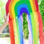 Cardboard Rainbow Streamers - Cultivating Brilliant Minds a piece of cardboard cut and painted like a rainbow with streamers on the bottom