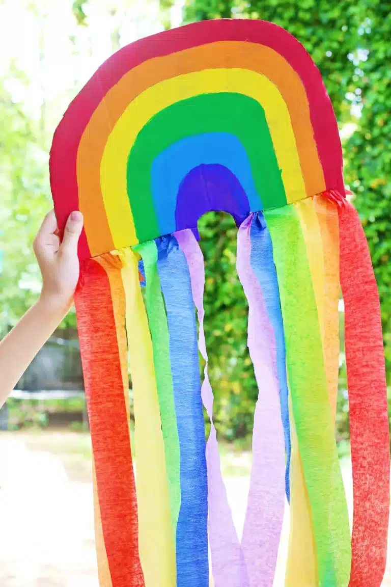 a piece of cardboard cut and painted like a rainbow with streamers on the bottom