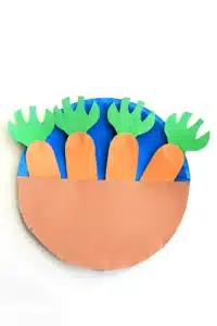 a paper plate painted blue with construction paper carrots