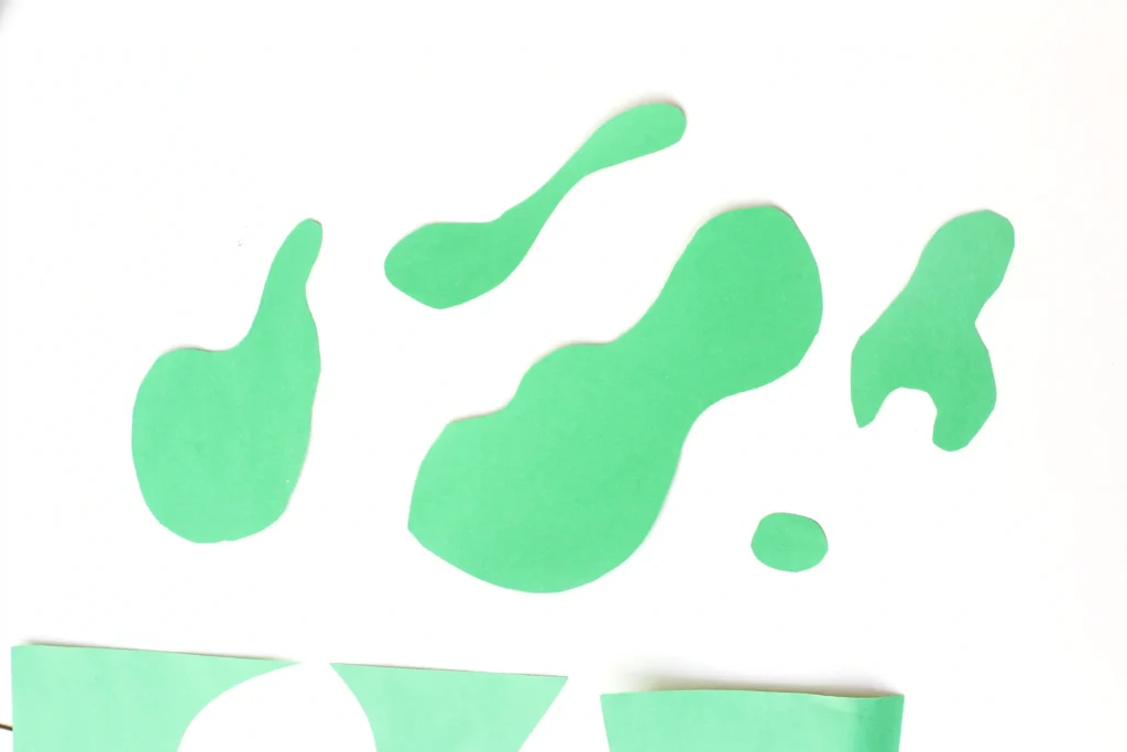 Letter E Earth Craft - Cultivating Brilliant Minds Abstract lime-green shapes on a white background; decorative graphic with fluid, blob-like forms