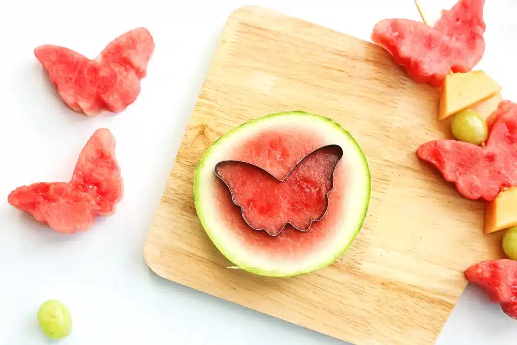 Spring Fruit Kabobs - Cultivating Brilliant Minds a butterfly cookie cutter on top of a slice of watermelon