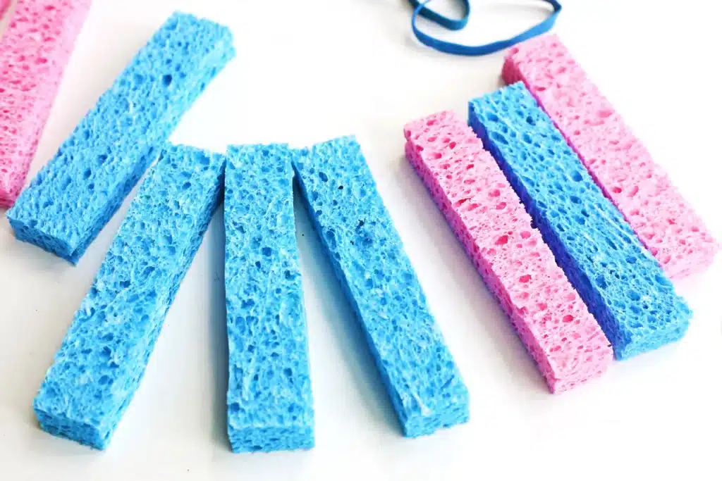 DIY Sponge Toss - Cultivating Brilliant Minds Colorful blue and pink kitchen sponges arranged on a white surface.