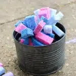 a diy sponge toss outdoor activity for kids with a bucket full of water and sponges