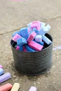 a diy sponge toss outdoor activity for kids with a bucket full of water and sponges