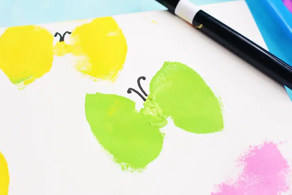 Sponge Painted Butterflies - Cultivating Brilliant Minds a sponge stamped butterfly with an antennae drawn on